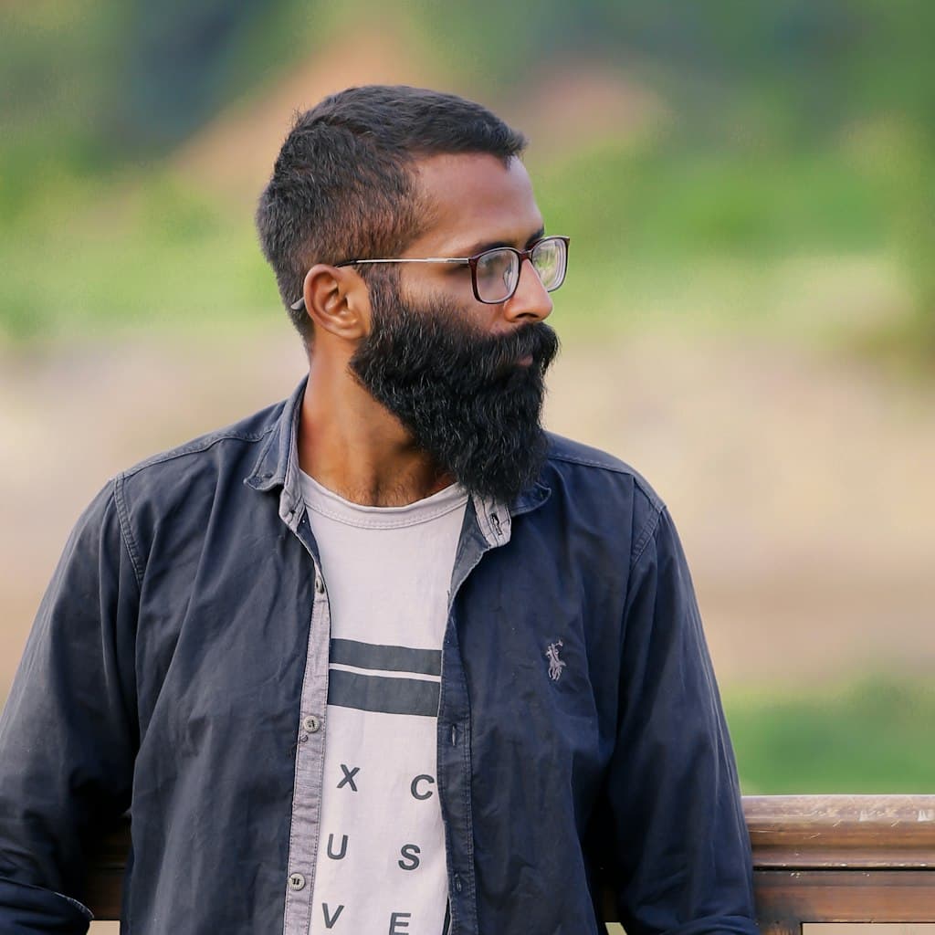 Portrait photo of bearded man in his 40s wearing glasses used as source for caricature comparison