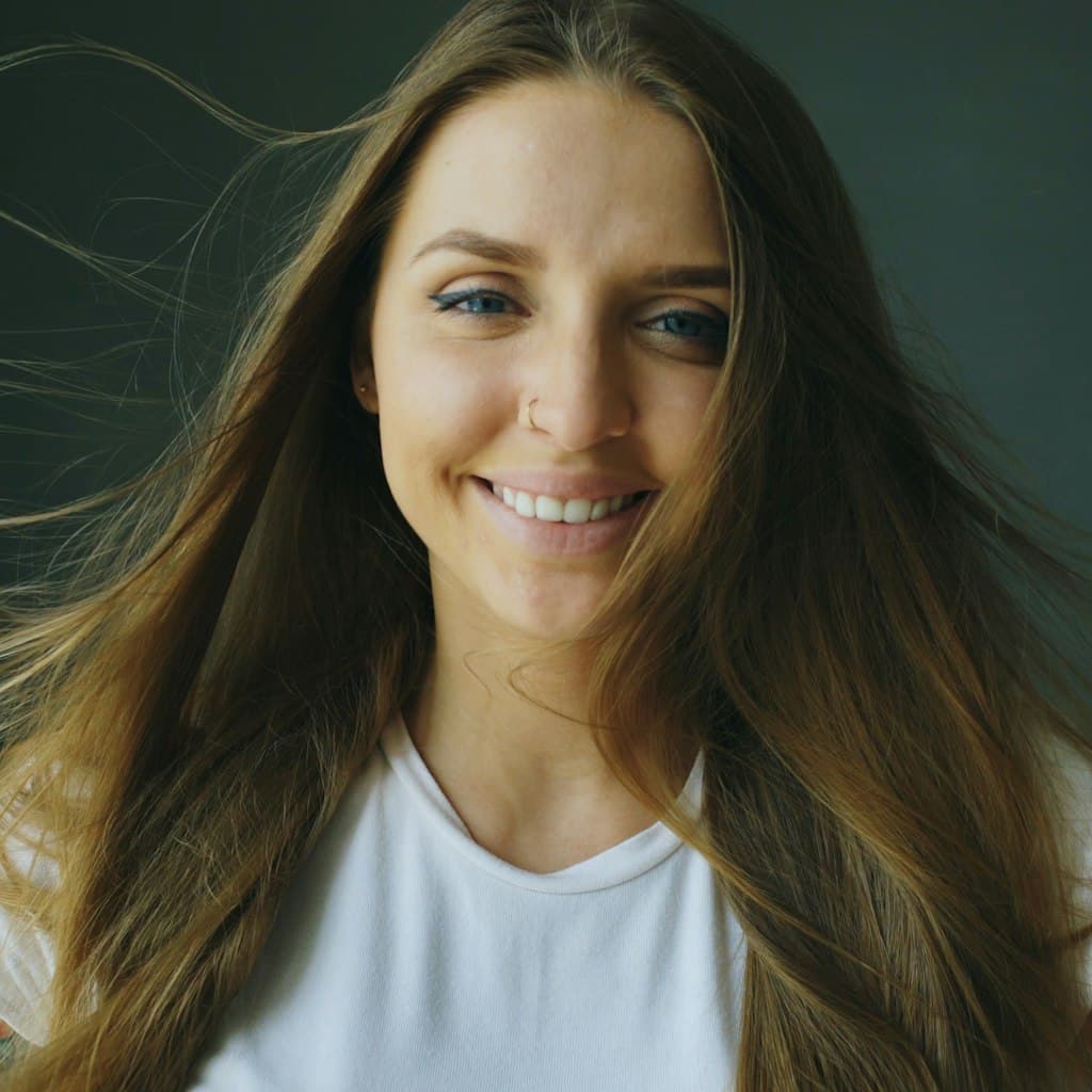 Portrait photo of smiling woman with long hair used as source for caricature comparison
